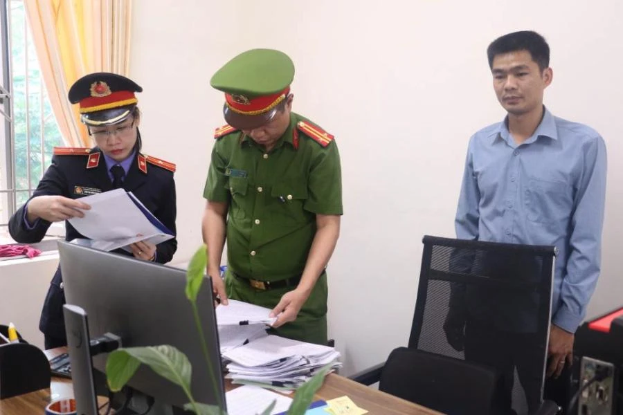 Lực lượng chức năng khám xét nơi làm việc của bị can Phạm Văn Tài. Ảnh: CA