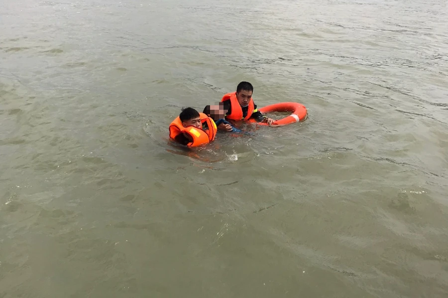 Cảnh sát cứu nạn cứu hộ bơi ra cứu đưa người phụ nữ vào bờ.