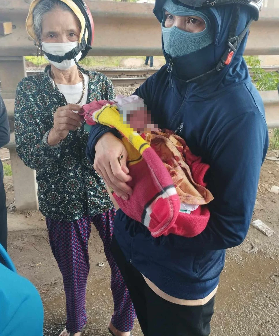 Người dân phát hiện và bế bé sơ sinh bị bỏ rơi dưới chân cầu vượt quốc lộ 1A.