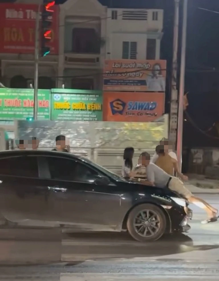 Chiếc xe hơi đi qua đoạn đường có tín hiệu đèn đỏ.