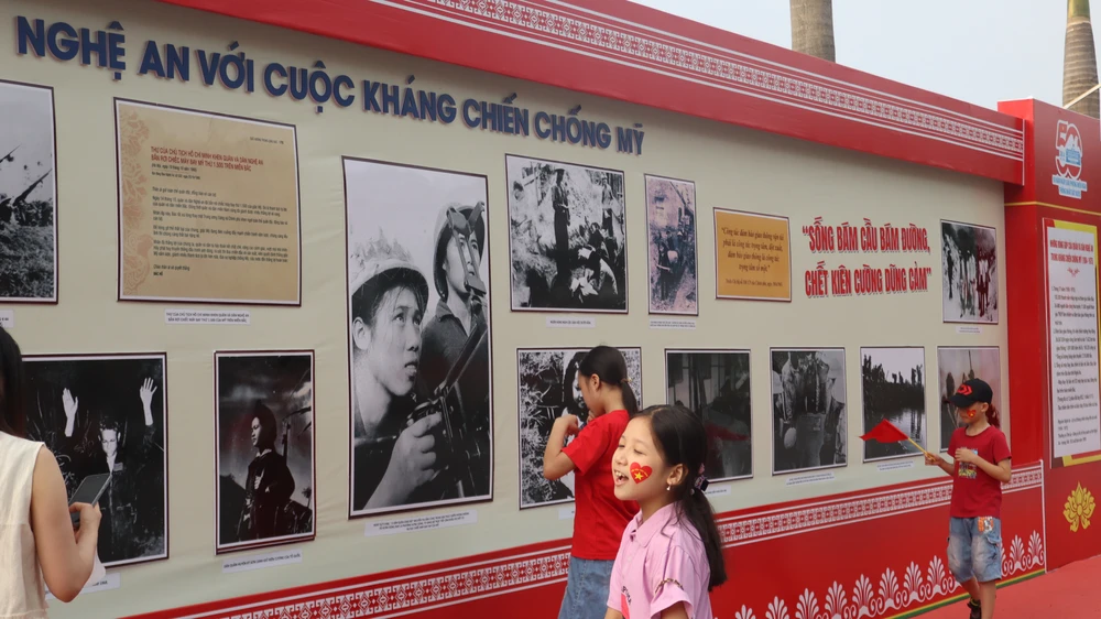 Người dân, học sinh đến xem trưng bày chuyên đề “50 năm thống nhất và khát vọng vươn mình” tại Quảng trường Hồ Chí Minh, TP Vinh, Nghệ An. Ảnh; ĐẮC LAM.