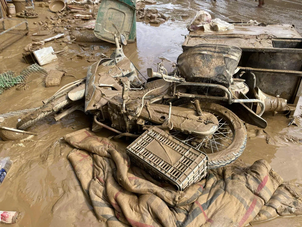 Xe máy, chăn màn của người dân ở xã Tương Dương lẫn trong bùn đất.
