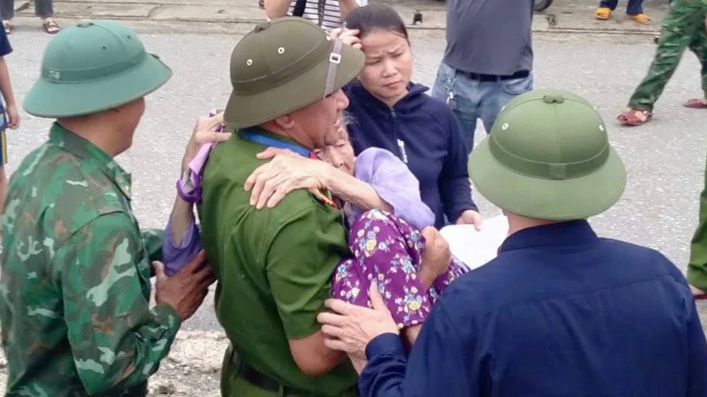 Cụ bà ở phường Sông Trí (tỉnh Hà Tĩnh) được lực lượng công an giúp đỡ sơ tán đến nơi an toàn.