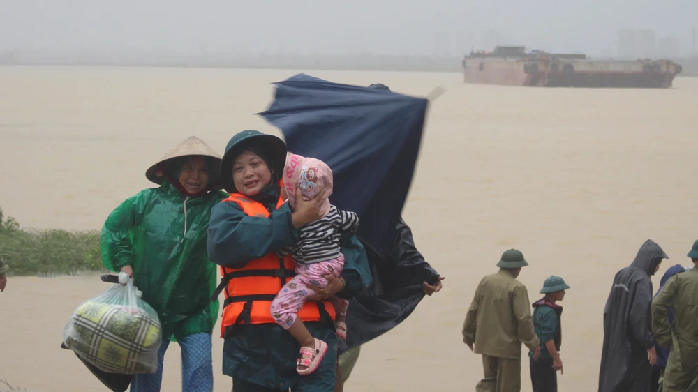 Trẻ em ở làng ốc đảo Hồng Lam (xã Nghi Xuân, tỉnh Hà Tĩnh) được bế chạy tránh bão số 10.