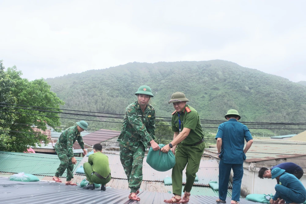 Bộ đội, công an, dân quân giúp người dân gia cố nhà cửa trước khi bão số 10 đổ bộ.
