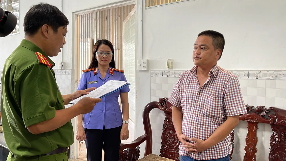 Tống đạt quyết định khởi tố vụ án, khởi tố bị can, lệnh bắt bị can để tạm giam đối với Nguyễn Sỹ Hùng. Ảnh: CHÂU ANH