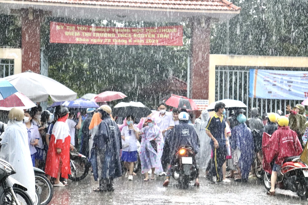 Vừa thi xong môn Toán, thí sinh đã có ô dù che chắn vì mưa lớn ảnh 3