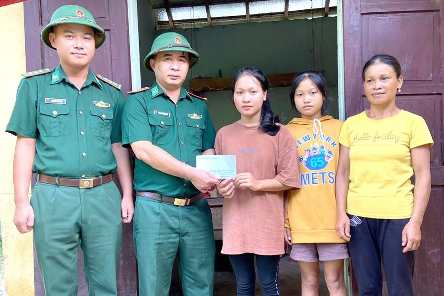Đại diện Đồn biên phòng Cà Xèng, Bộ đội biên phòng tỉnh Quảng Bình trao tiền hỗ trợ em Cao Thị Lệ Hằng nhập học. Ảnh: Đồn biên phòng Cà Xèng
