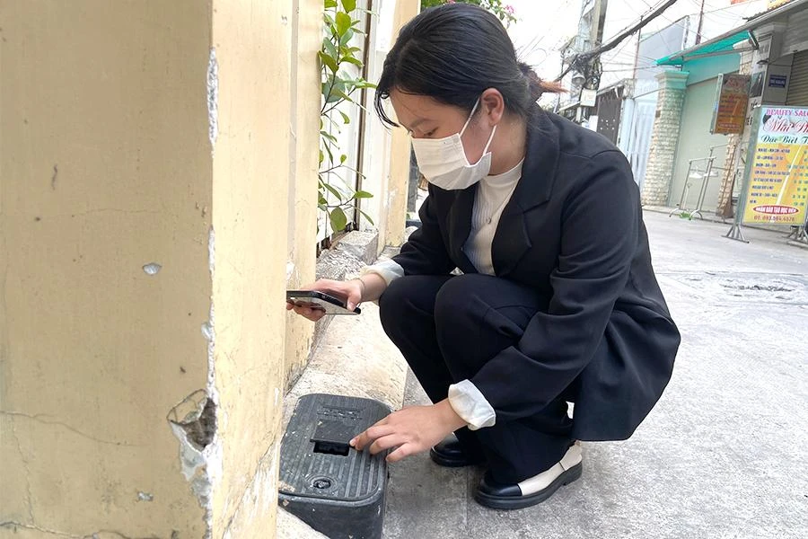 Người dân kiểm tra đồng hồ nước. Ảnh: HUỲNH THƠ