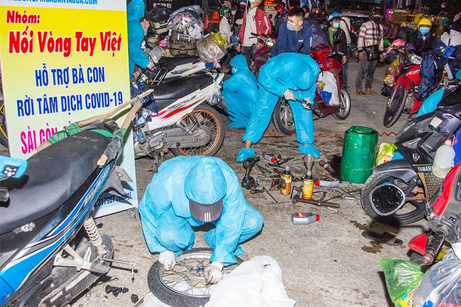 Nhóm của anh Phước sửa xe cho người dân chạy khỏi tâm dịch. Ảnh: NVCC