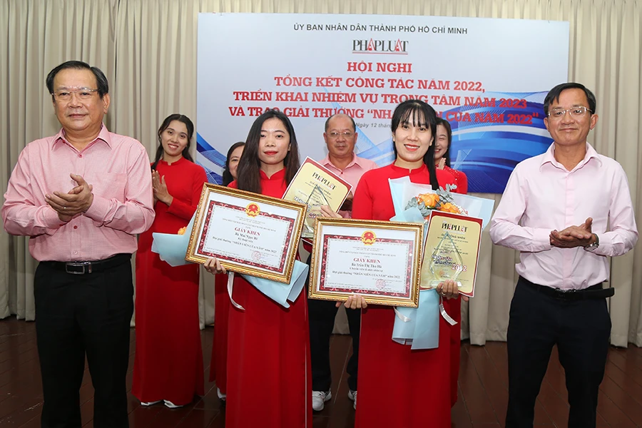 Ông Mai Ngọc Phước (trái), Tổng biên tập báo Pháp Luật TP.HCM, trao giải thưởng cho hai nhân viên xuất sắc năm 2022. Ảnh: HOÀNG GIANG