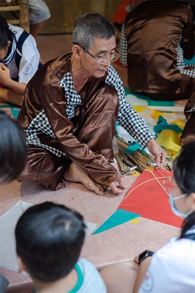 Nghệ nhân Nguyễn Thanh Vân truyền nghề làm diều cho lớp trẻ. Ảnh: NVCC