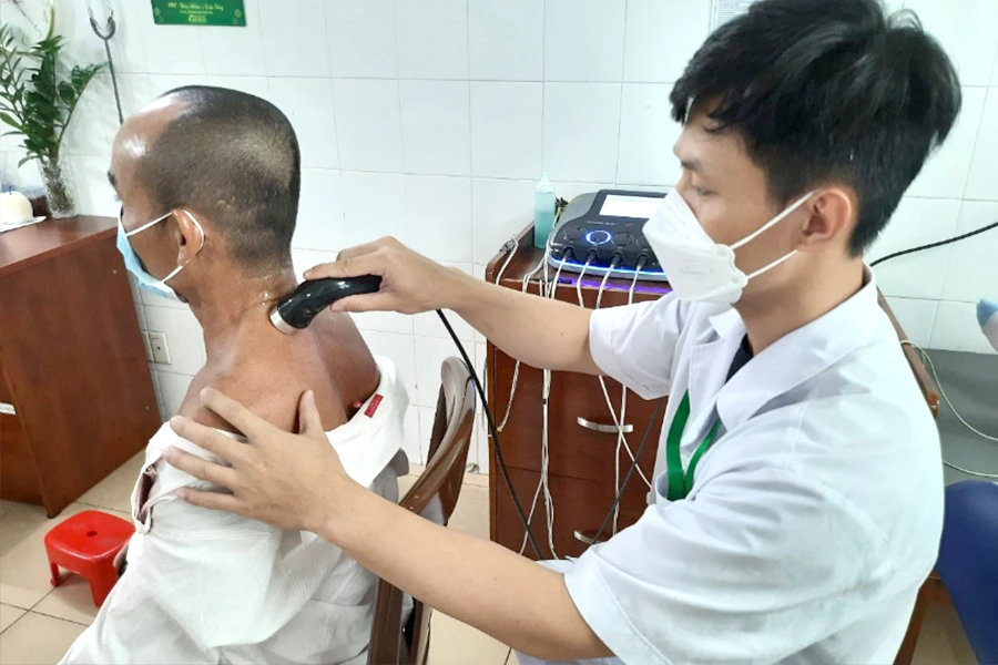 Một bệnh nhân đang được điều trị bằng điện xung kết hợp siêu âm. Ảnh: TRẦN NGỌC