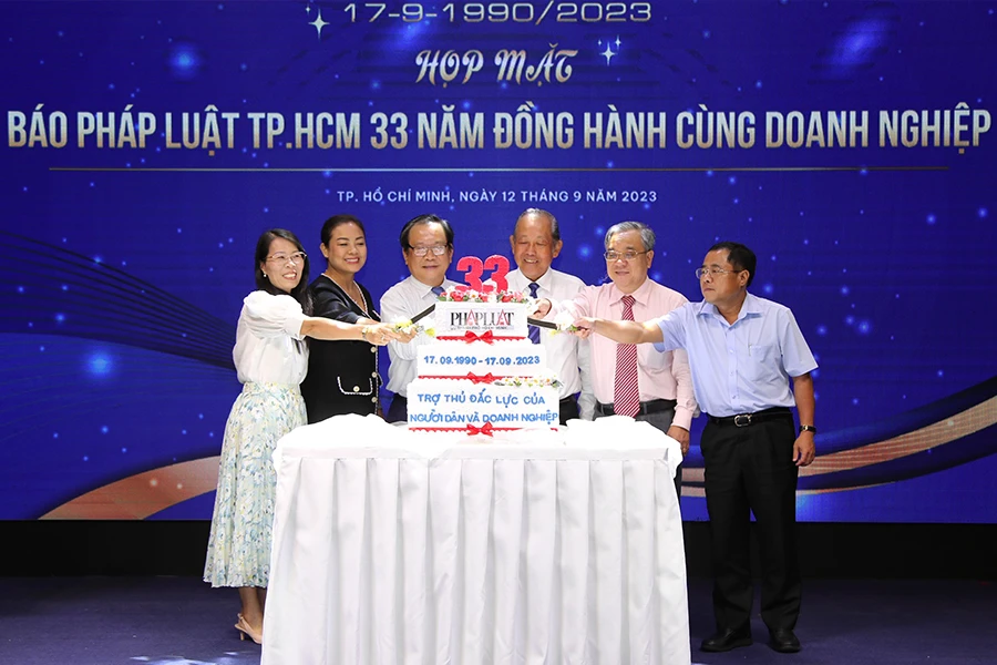 Ông Trương Hòa Bình, nguyên Phó Thủ tướng thường trực, cùng Tổng Biên tập báo Pháp Luật TP.HCM Mai Ngọc Phước và các khách mời cắt bánh chúc mừng. Ảnh: HOÀNG GIANG