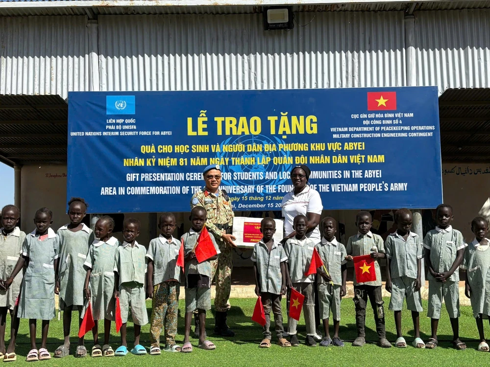 Trung tá Trần Thanh Sơn, Phó Đội trưởng Đội Công binh số 4 trao tặng dụng cụ học tập cho học sinh Abyei. Ảnh: HẢI YẾN