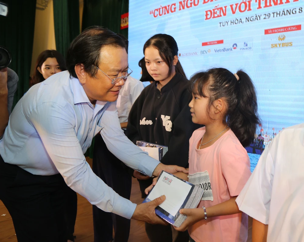 Tổng Biên tập Mai Ngọc Phước trao quà cho học sinh trong Chương trình “Cùng ngư dân thắp sáng đèn trên biển” đến với Tuy Hòa. Ảnh: NHÓM PV