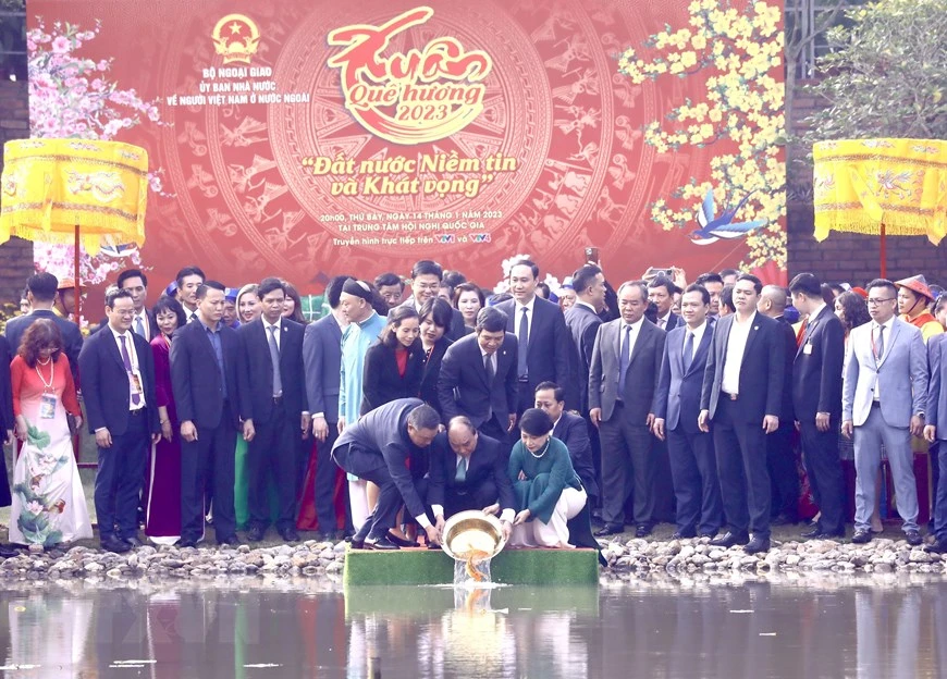 Chủ tịch nước Nguyễn Xuân Phúc và Phu nhân cùng các đại biểu kiều bào thả cá chép tiễn ông Công, ông Táo theo phong tục truyền thống tại Hồ sen trong Khu di tích Hoàng Thành Thăng Long. Ảnh: TTXVN