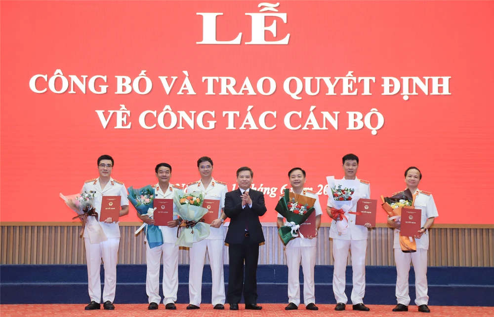 Viện trưởng VKSND tối cao Lê Minh Trí trao quyết định, tặng hoa chúc mừng lãnh đạo các vụ. Ảnh: VKS