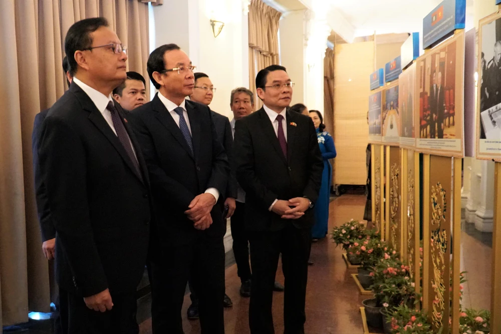Bí thư Nguyễn Văn Nên cùng đoàn đại biểu Lào tham quan không gian triển lãm tranh, ảnh về mối quan hệ hữu nghị giữa hai nước Việt Nam - Lào. Ảnh: BẢO PHƯƠNG
