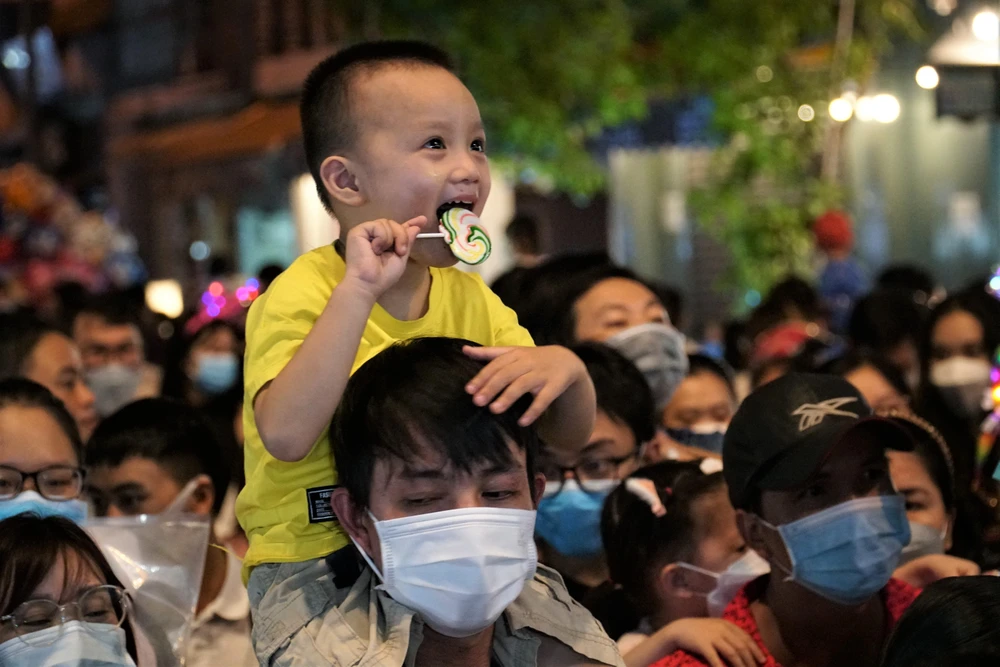 Sợ cảnh chen lấn, em bé được ba cõng trên vai.