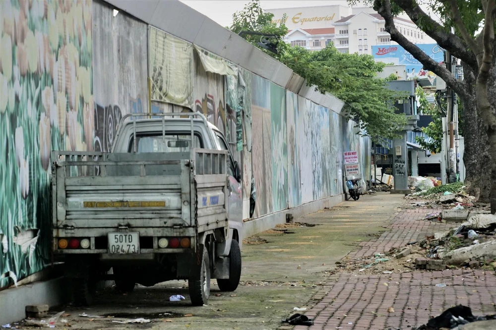 Hiện khu vực này được tận dụng làm nơi đậu xe, tập kết rác, ve chai của người dân làm cho bộ mặt đô thị trở nên xấu xí. Ảnh: BẢO PHƯƠNG Hiện khu vực này được tận dụng làm nơi đậu xe, tập kết rác, ve chai của người dân làm cho bộ mặt đô thị trở nên xấu xí. Ảnh: BẢO PHƯƠNG