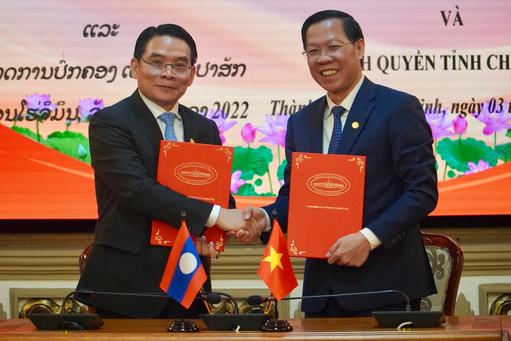 Chủ tịch Phan Văn Mãi và ông Vilayvong Boutdakham, Bí thư, Tỉnh trưởng tỉnh Champasak (Lào) cùng ký biên bản ghi nhớ phương hướng hợp tác giữa TP.HCM và tỉnh Champasak. Ảnh: BẢO PHƯƠNG