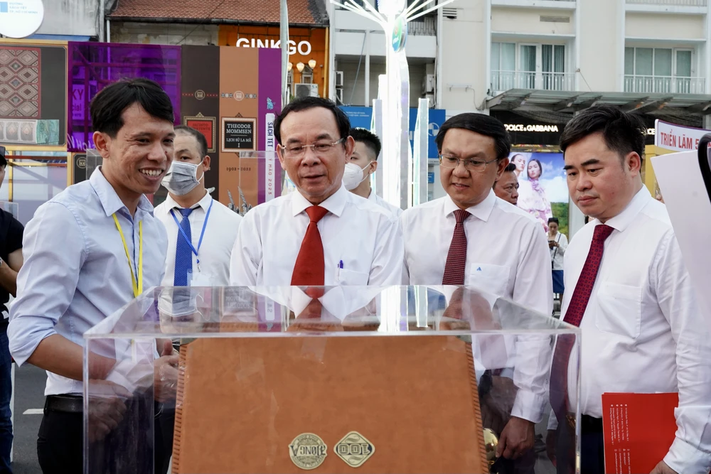 Bí thư Thành ủy TP.HCM Nguyễn Văn Nên (thứ 2 từ trái sang) nghe giới thiệu về quyển sách phiên bản giới hạn. Ảnh: BẢO PHƯƠNG