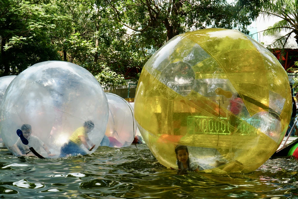 Các em nhỏ thích thú với các trò chơi tại Công viên Đầm Sen. Ảnh: BẢO PHƯƠNG