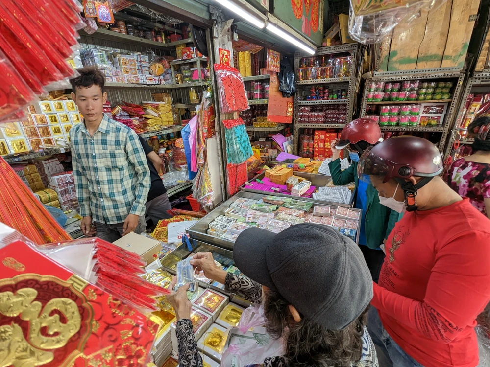 Cùng lúc tại khu vực bán vàng mã ở chợ Thiếc đã tấp nập người mua sắm đồ cúng lễ. Ảnh: VĂN THUẬN