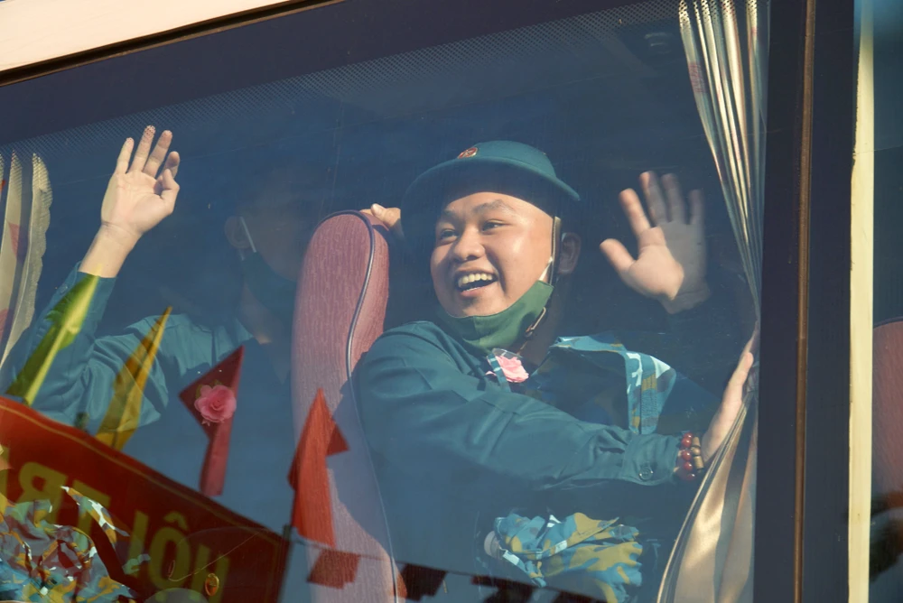 Các thanh niên vẫy tay chào gia đình, bạn bè trước khi lên đường. Ảnh: BẢO PHƯƠNG Các thanh niên vẫy tay chào gia đình, bạn bè trước khi lên đường. Ảnh: BẢO PHƯƠNG