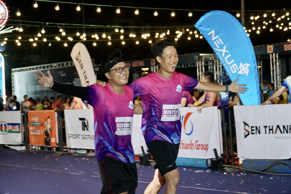Đến hơn 2 giờ ngày 26-3, nhiều tuyển thủ chạy cự ly 21 km đã về đích. Chạy bộ xuyên đêm thực sự là một thử thách không hề dễ với nhiều người, nhất là quãng đường dài đến 21 km, thế nhưng có lẽ được khám phá trọn vẹn vẻ đẹp thơ mộng về đêm của TP qua từng bước chân đã tạo động lực để các vận động viên vượt qua mọi mệt mỏi trên các cung đường. Ảnh: BẢO PHƯƠNG