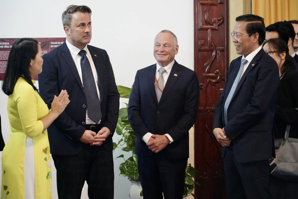 Thủ tướng Luxembourg Xavier Bettel (thứ 2, từ trái sang) nghe hướng dẫn viên giới thiệu về kiến trúc Dinh Độc Lập. Ảnh: BẢO PHƯƠNG