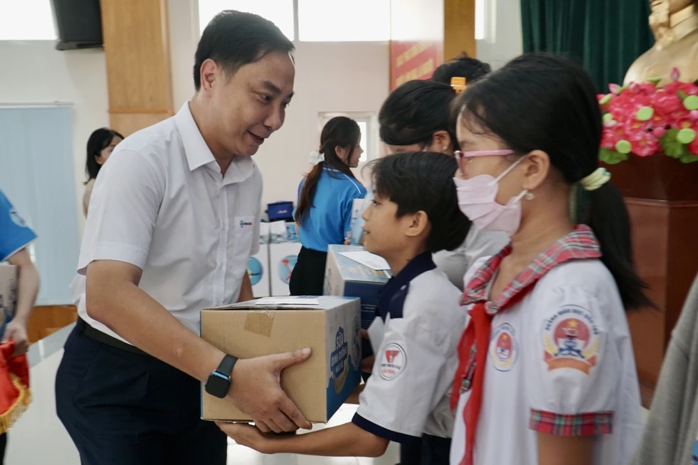Ông Nguyễn Thanh Nhã, Phó Tổng giám đốc Tổng Công ty điện lực TP.HCM, trao quà và học bổng cho các em học sinh huyện Cần Giờ.