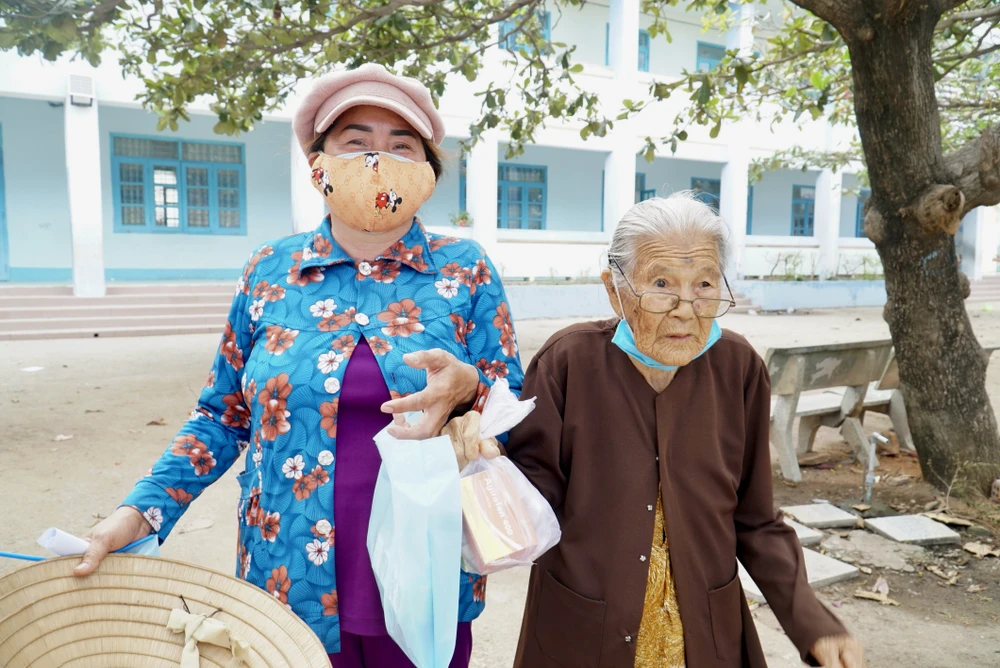 Nhân dịp có chương trình khám bệnh, phát thuốc miễn phí, bà Nguyễn Thị Hà dẫn mẹ chồng là cụ Lê Thị Trọng (ngụ xã Phước Diêm) đến thăm khám, gặp bác sĩ. Cụ Trọng đã gần 90 tuổi, là bệnh nhân lớn tuổi nhất tại buổi thăm khám hôm nay. Bà Hà cho biết, cụ Trọng bị cao huyết áp và đau xương khớp đã lâu nhưng vì hoàn cảnh còn khó khăn, lại thêm tuổi cụ đã lớn, không tiện đi lại nên gia đình ít khi đưa cụ đến bệnh viện. "Chương trình này tổ chức gần nhà nên gia đình tôi tranh thủ dẫn cụ đến gặp bác sĩ. Dù người dân, hàng xóm xung quanh đến đông nhưng bác sĩ tận tình nên cụ vui lắm. Mong sao sẽ tiếp tục có nhiều chương trình ý nghĩa thế này đến làng, xã nhà tôi" - bà Hà hào hứng. Ảnh: BẢO PHƯƠNG