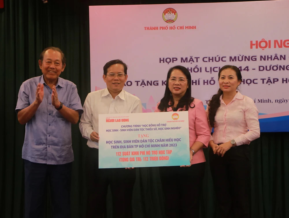 Bà Trần Kim Yến (thứ hai, từ phải sang) nhận bảng tượng trưng 112 suất kinh phí hỗ trợ học tập. Ảnh: BP