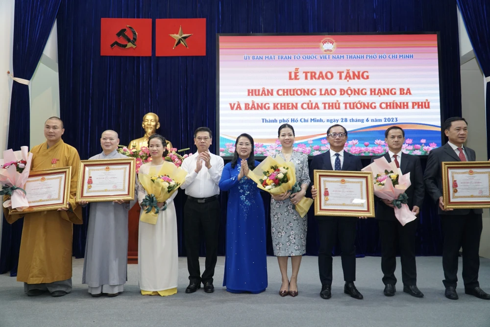 Chủ tịch Ủy ban MTTQ Việt Nam TP.HCM Trần Kim Yến (giữa) và Phó Chủ tịch HĐND TP.HCM Nguyễn Văn Dũng (thứ 4 từ trái sang) trao Huân chương Lao động hạng Ba cho ba tập thể và một cá nhân. Ảnh: BP