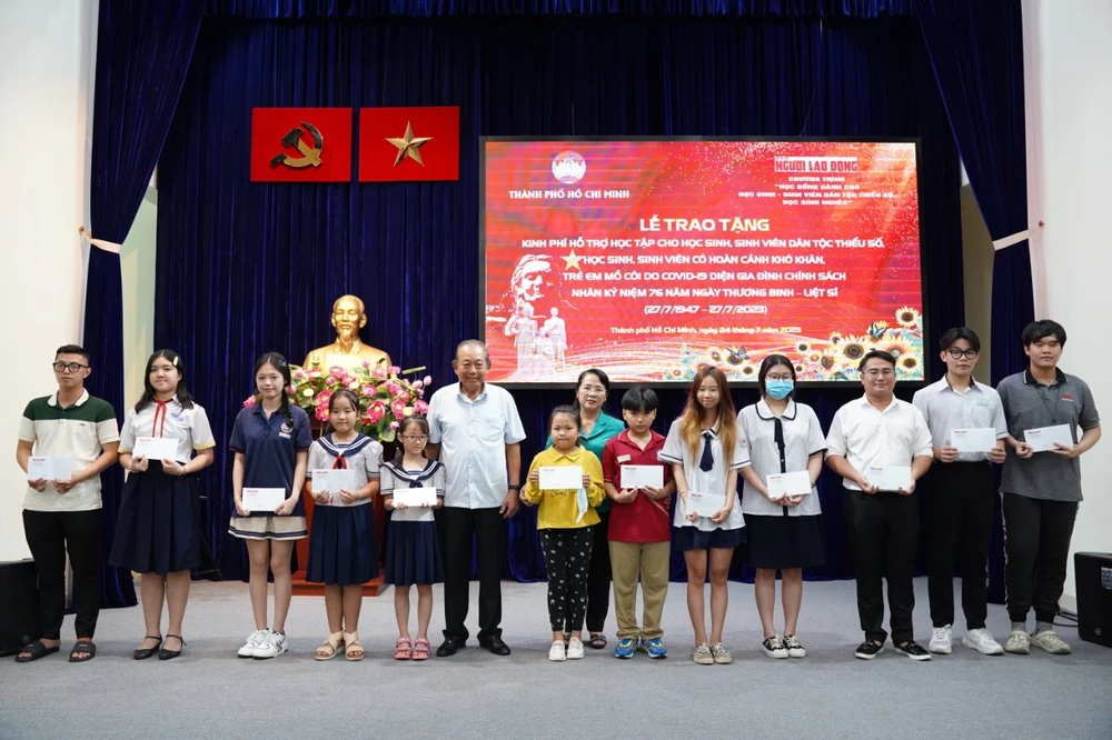 Nguyên Phó Thủ tướng Trương Hòa Bình và Chủ tịch Ủy ban MTTQ Việt Nam TP.HCM Trần Kim Yến trao học bổng cho các em HSSV. Ảnh: T.V