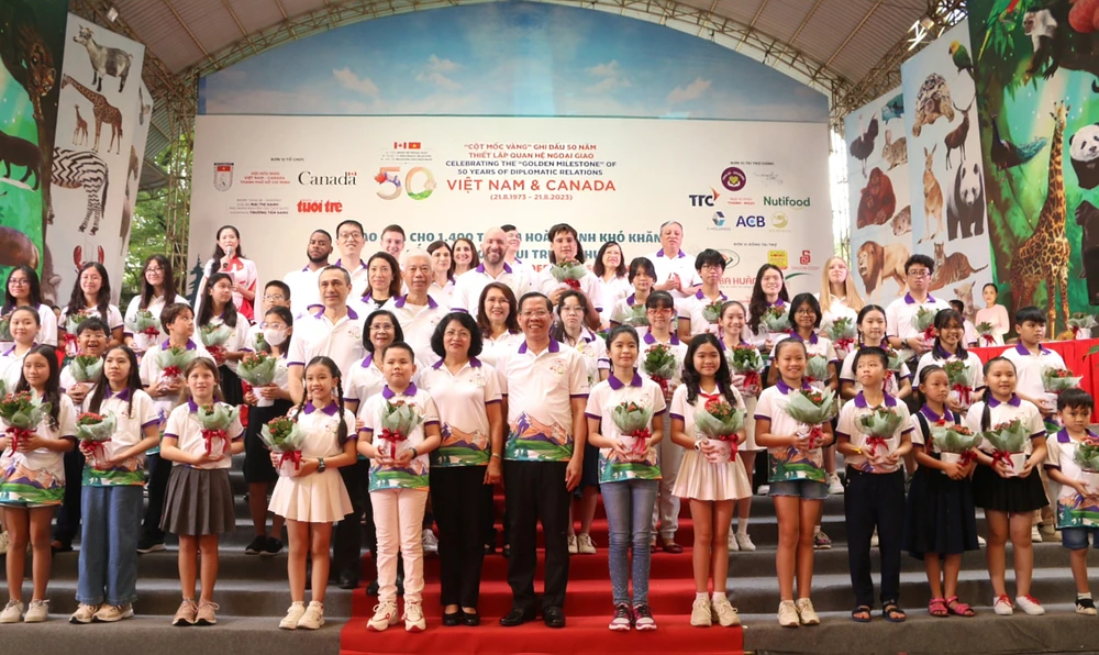 Lãnh đạo TP trao những chậu hoa sống đời cho các em học sinh tiêu biểu của hai nước. Ảnh: THIỆN HỢP.