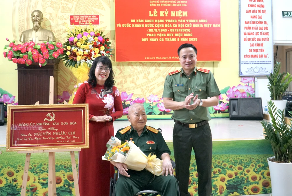 Trung tướng Mai Hoàng và bà Trương Lê Mỹ Ngọc trao khánh vàng và Huy hiệu 80 năm tuổi Đảng cho ông Nguyễn Phước Chí. Ảnh: BẢO PHƯƠNG