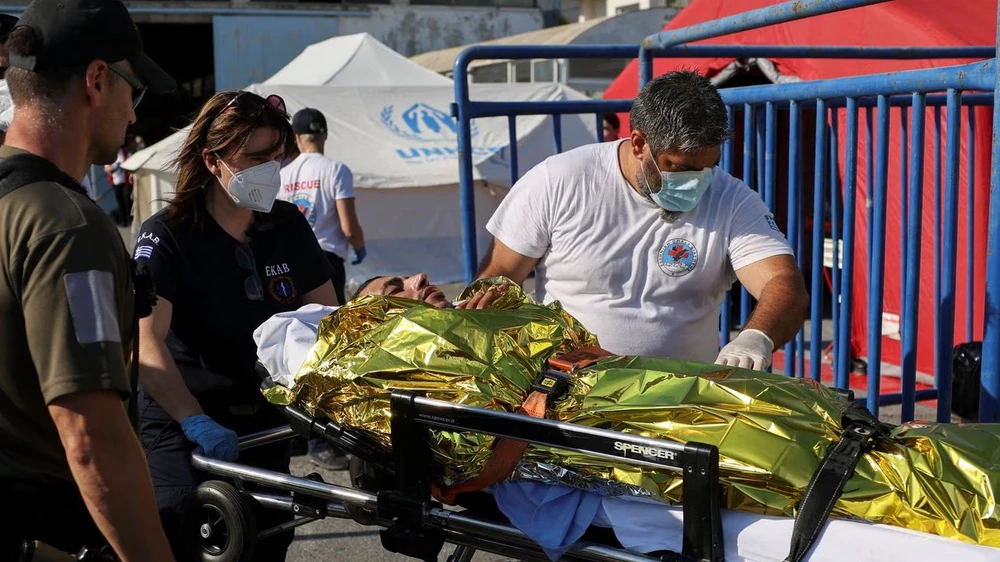 Nhân viên cứu hộ đưa nạn nhân đắm tàu tị nạn tới bệnh viện địa phương trong ngày 14-6. Ảnh: REUTERS