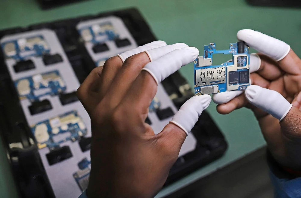 Công nhân lắp ráp linh kiện điện thoại tại nhà máy của Dixon. Ảnh: BLOOMBERG Công nhân lắp ráp linh kiện điện thoại tại nhà máy của Dixon. Ảnh: BLOOMBERG