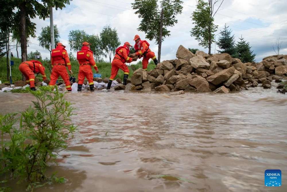 Lực lượng cứu hộ dùng đá để chặn lũ dâng tại tỉnh Hắc Long Giang (Trung Quốc). Ảnh: TÂN HOA XÃ