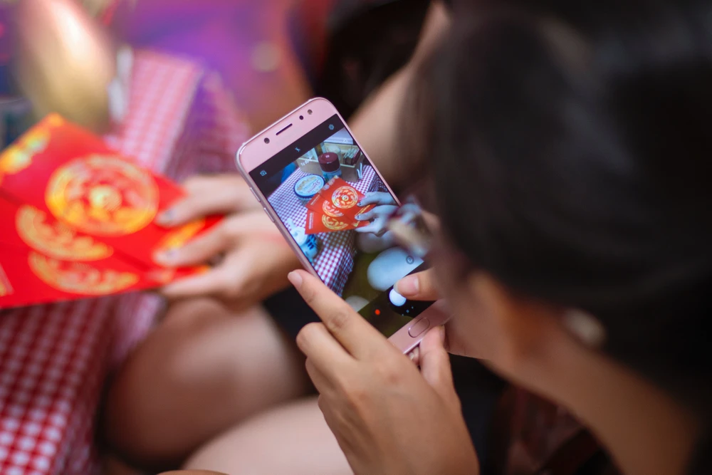 Cả nhà quây quần bên chiếc điện thoại vào giờ giao thừa để gọi cho người thân; cũng chúc tụng, trò chuyện và có cả… lì xì online. Ảnh minh họa: TAAN HUYN/ UNSPLASH Cả nhà quây quần bên chiếc điện thoại vào giờ giao thừa để gọi cho người thân; cũng chúc tụng, trò chuyện và có cả… lì xì online. Ảnh minh họa: TAAN HUYN/ UNSPLASH