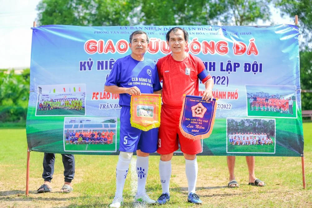 Ông Huỳnh Văn Phượng – Chủ nhiệm CLB Lão tướng Bình Tân và cựu tuyển thủ Huỳnh Hồng Sơn thân thiện trao nhau cờ lưu niệm trước giờ bóng lăn.