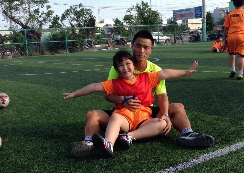 Con gái Lê Đỗ Hồng Lam hào hứng xỏ giày theo ba ra sân tập bóng đá cho các bạn.