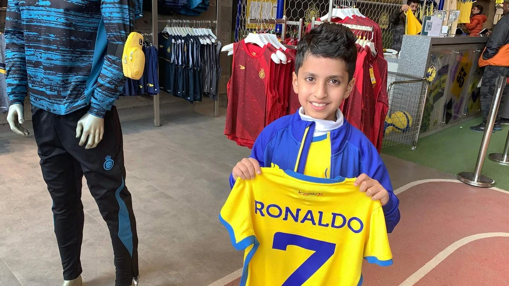 Fan nhí thích thú khoe chiếc áo đấu của thần tượng. Ảnh: GETTY.