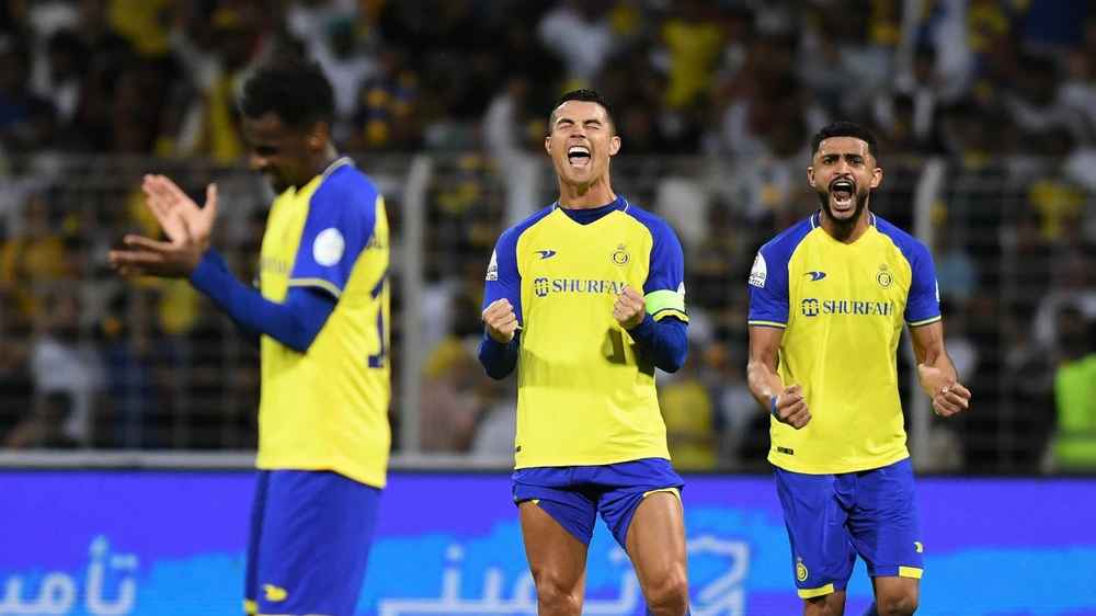 Đội trưởng cũ của Al Nassr vui vẻ nhường chiếc băng đội trưởng cho tân binh Ronaldo. Ảnh: GETTY.