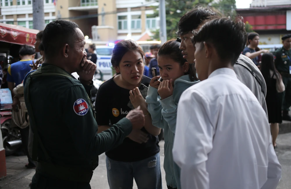 Cảnh sát Campuchia vừa làm nhiệm vụ giữ gìn an ninh trật tự, vừa hướng dẫn các bạn trẻ cách nhận vé miễn phí. Ảnh: ANH PHƯƠNG.