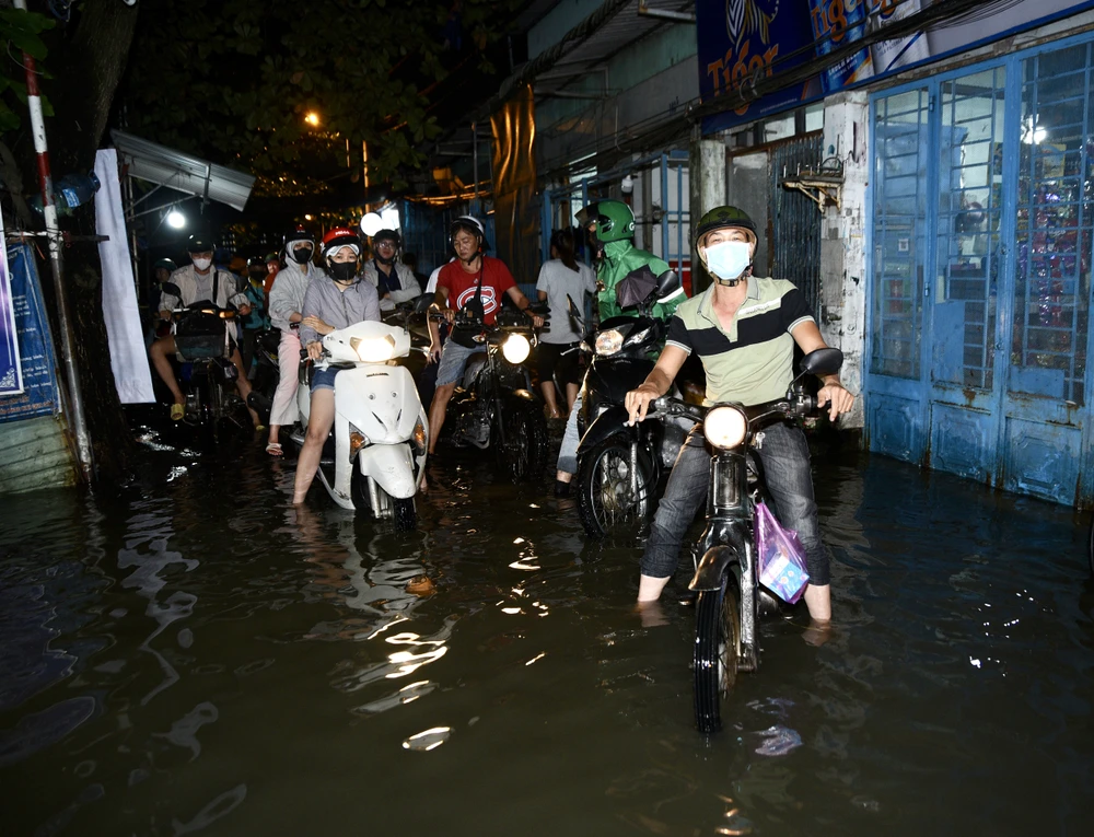Triều cường dâng, người dân TP.HCM bì bõm lội về trong đêm