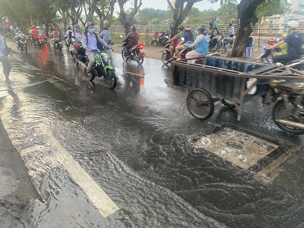 nước từ sông Sài Gòn và các miệng cống bắt đầu dâng cao và tràn lên đường gây ngập lụt úng.JPG